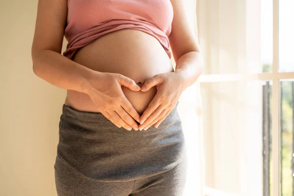 Mujer embarazada feliz y esperando un bebé en casa. — Foto de Stock