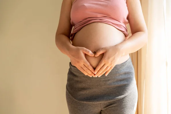 Mujer embarazada feliz y esperando un bebé en casa. — Foto de Stock