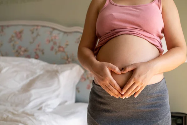 Mujer embarazada feliz y esperando un bebé en casa. — Foto de Stock