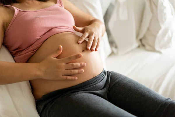 Mujer embarazada feliz y esperando un bebé en casa. — Foto de Stock