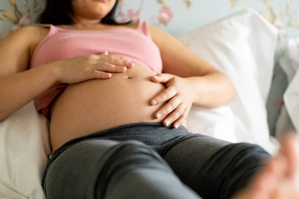 Mujer embarazada feliz y esperando un bebé en casa. — Foto de Stock