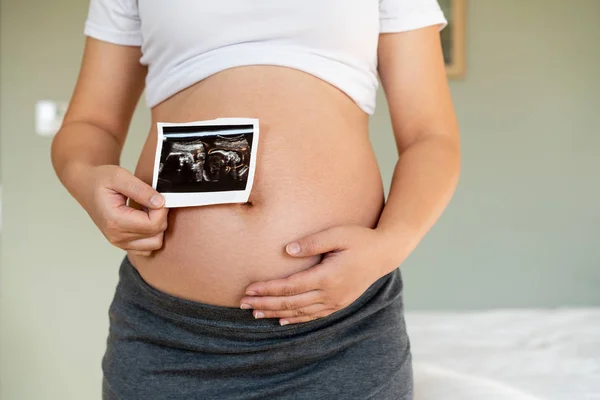 Mujer embarazada feliz y esperando un bebé en casa. — Foto de Stock