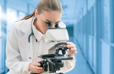 Bilim adamı araştırmacı laboratuvarda mikroskop kullanır