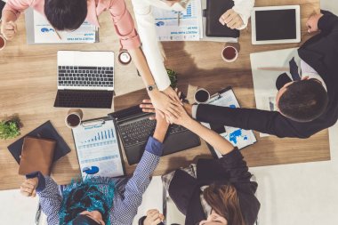 Takım çalışması çalışanları toplantıda el ele tutuşuyor.