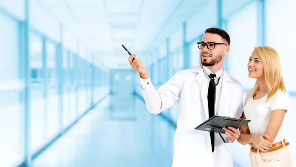 Doctor with patient pointing at empty copy space.