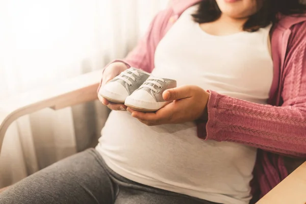 Mujer embarazada feliz y esperando un bebé en casa. — Foto de Stock