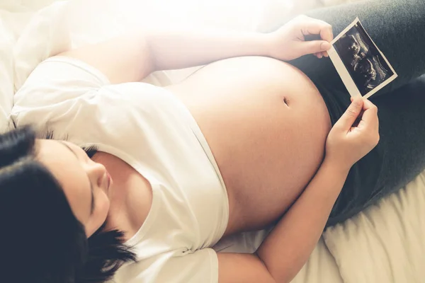 Mujer embarazada feliz y esperando un bebé en casa. — Foto de Stock