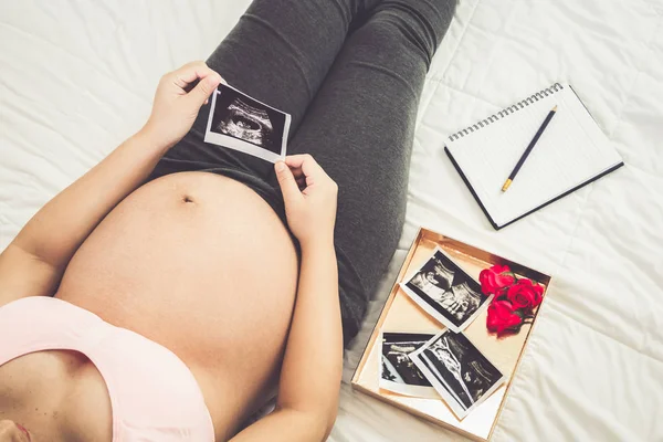 Mujer embarazada feliz y esperando un bebé en casa. — Foto de Stock