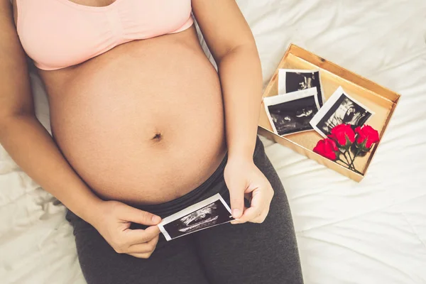 Mujer embarazada feliz y esperando un bebé en casa. — Foto de Stock