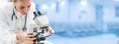 Bilim adamı araştırmacı laboratuvarda mikroskop kullanır