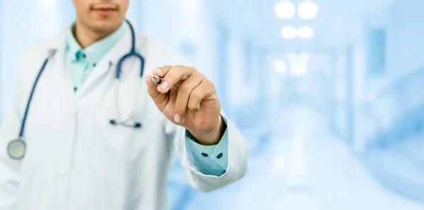 Doctor apuntando pluma en el espacio vacío para su texto. — Foto de Stock