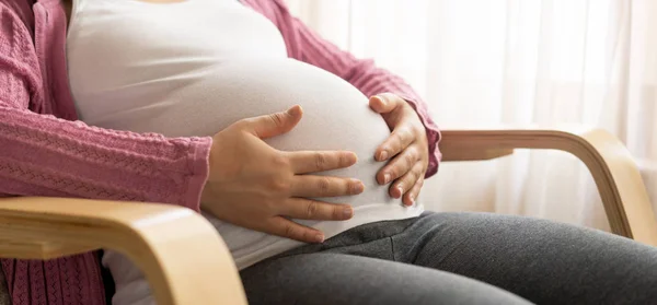 Mujer embarazada feliz y esperando un bebé en casa. — Foto de Stock