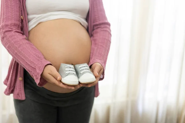 Mujer embarazada feliz y esperando un bebé en casa. — Foto de Stock