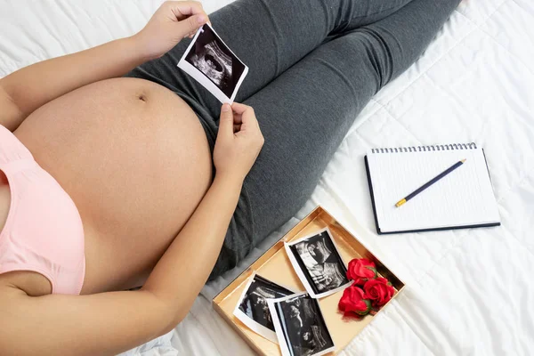 Mujer embarazada feliz y esperando un bebé en casa. — Foto de Stock