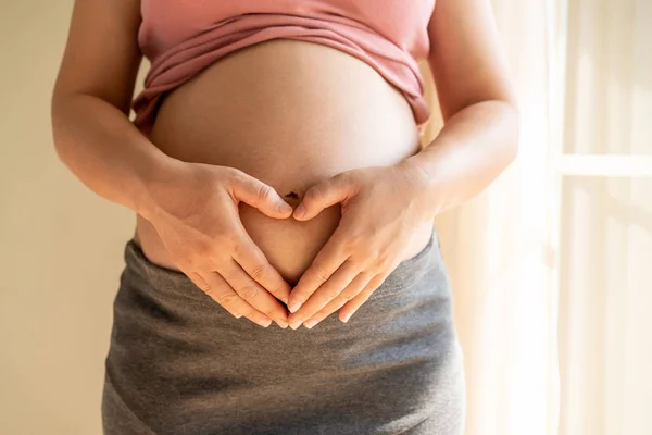 Mujer embarazada feliz y esperando un bebé en casa. — Foto de Stock