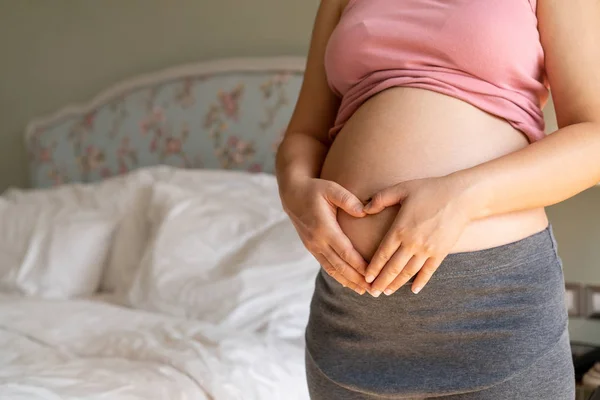 Mujer embarazada feliz y esperando un bebé en casa. — Foto de Stock