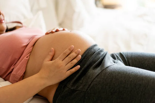 Happy pregnant woman and expecting baby at home.