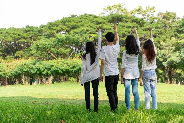 Jóvenes felices celebran en el parque público . — Foto de Stock