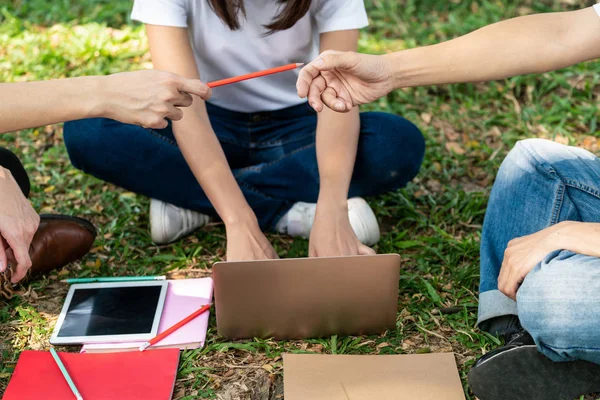 Team av unga studenter som studerar i parken. — Stockfoto