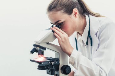 Hastane laboratuvarında mikroskop kullanan doktor.