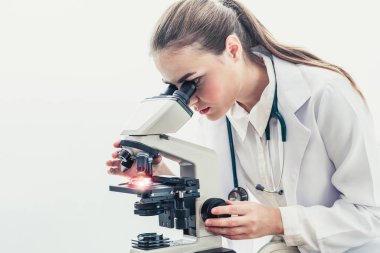 Hastane laboratuvarında mikroskop kullanan doktor.