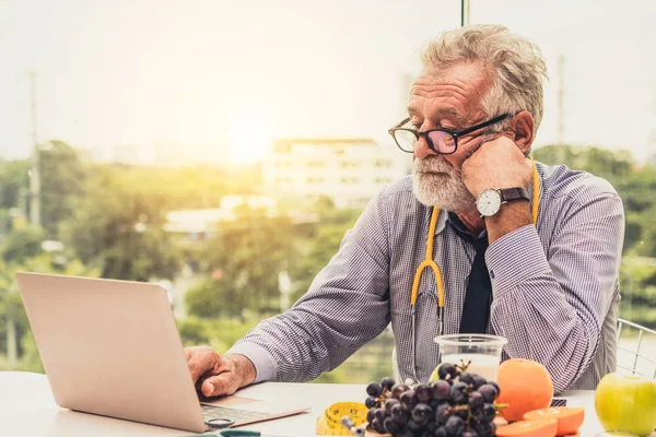 Senior médico nutricionista masculino que trabaja en el ordenador portátil . —  Fotos de Stock