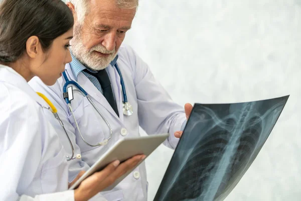 Médicos que trabajan con radiografías del tórax del paciente . — Foto de Stock