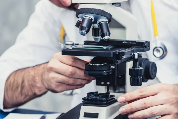 Médico usando microscopio en laboratorio hospitalario . —  Fotos de Stock