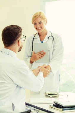 Hastanedeki doktor başka bir doktorla el sıkışıyor