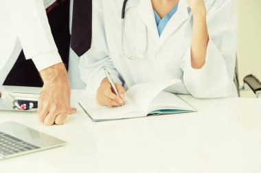 Doktor başka bir doktorla masada rapor yazıyor..