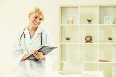 Hastane ofisinde çalışan genç kadın doktor.