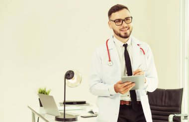 Hastanede tablet bilgisayar üzerinde çalışan doktor.