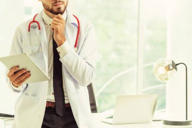 Hastanede tablet bilgisayar üzerinde çalışan doktor.