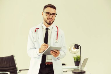 Hastanede tablet bilgisayar üzerinde çalışan doktor.