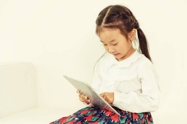 Tablet ile beyaz arka plan üzerinde küçük çocuk.