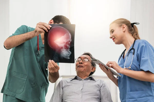 Команда врачей работает с рентгеновским снимком пациента . — стоковое фото