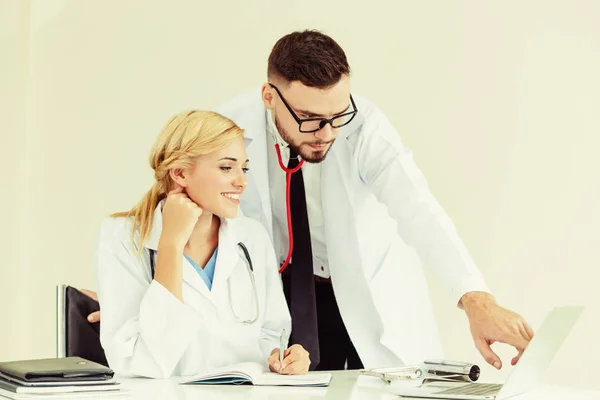 Il dottore a lavori ospedalieri su computer con compagno . — Foto Stock