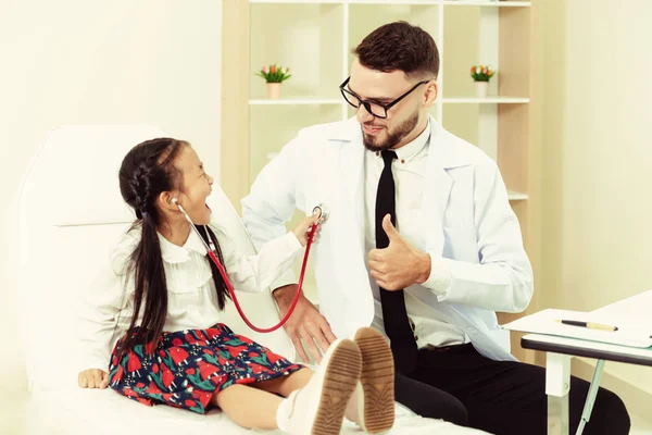 Gelukkig klein kind bezoek arts in ziekenhuis kantoor. — Stockfoto