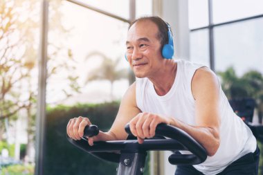 Fitness merkezinde bisiklet makinesi üzerinde Kıdemli adam egzersiz