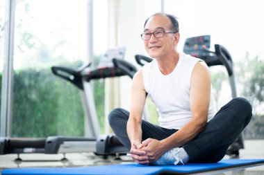 Kıdemli adam fitness merkezinde vücut germe yapmak.