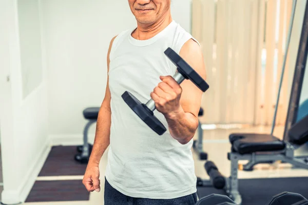 Senior man Lifting halter in fitness gym. — Stockfoto