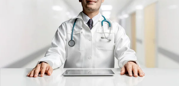 Doctor with tablet computer at hospital office.