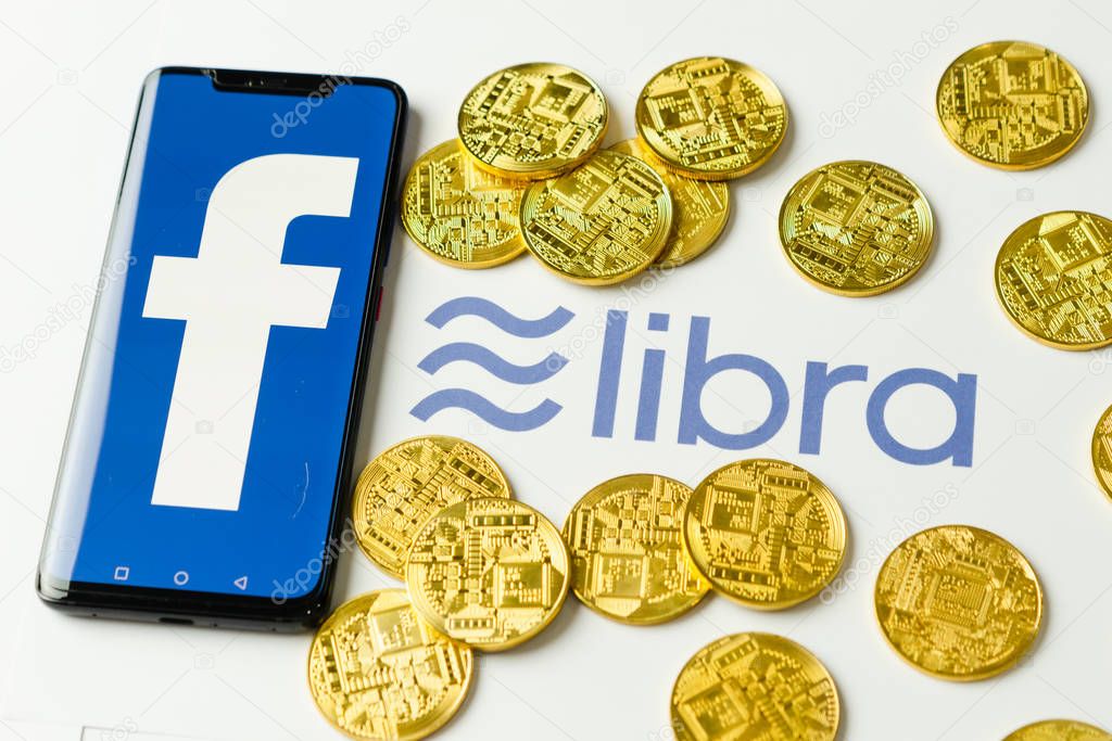 Bangkok, Thailand - July 2, 2019: Phone with Facebook logo on screen is placed on paper with Libra logo. Facebook reported to utilize new cryptocurrency called Libra expected to be used on Facebook.