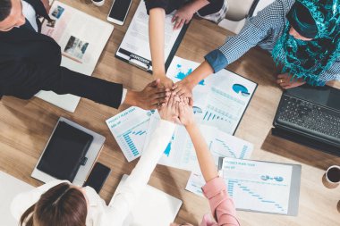 Takım çalışması çalışanları toplantıda el ele tutuşuyor.