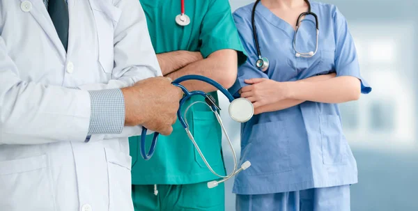 Médico que trabalha no hospital com outros médicos . — Fotografia de Stock