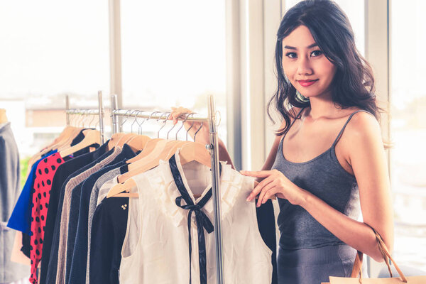 Beautiful woman shops for clothes in shopping mall