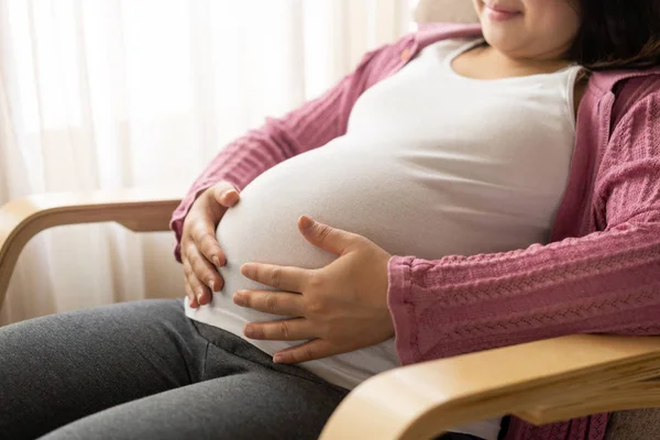 Mujer embarazada feliz y esperando un bebé en casa. — Foto de Stock