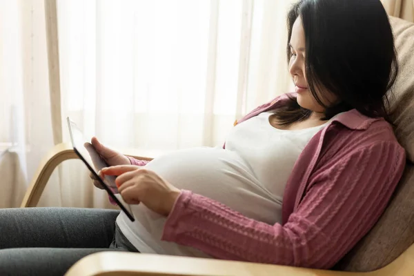 Mujer embarazada feliz y esperando un bebé en casa. — Foto de Stock