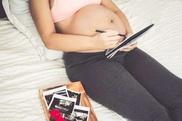 Mujer embarazada feliz y esperando un bebé en casa. — Foto de Stock