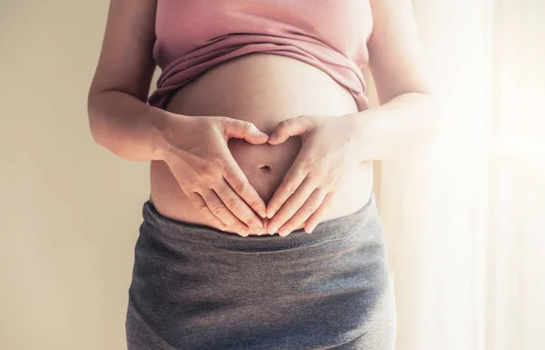 Mujer embarazada feliz y esperando un bebé en casa. — Foto de Stock